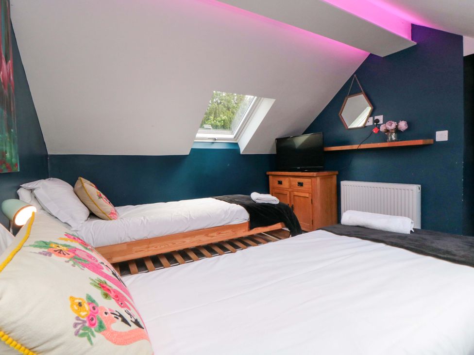 A bedroom with two beds and a television at Lawnswood