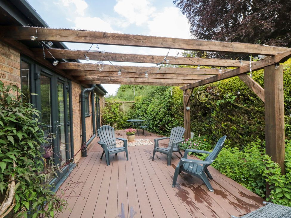 An outdoor area with a pergola and seating at Lawnswood