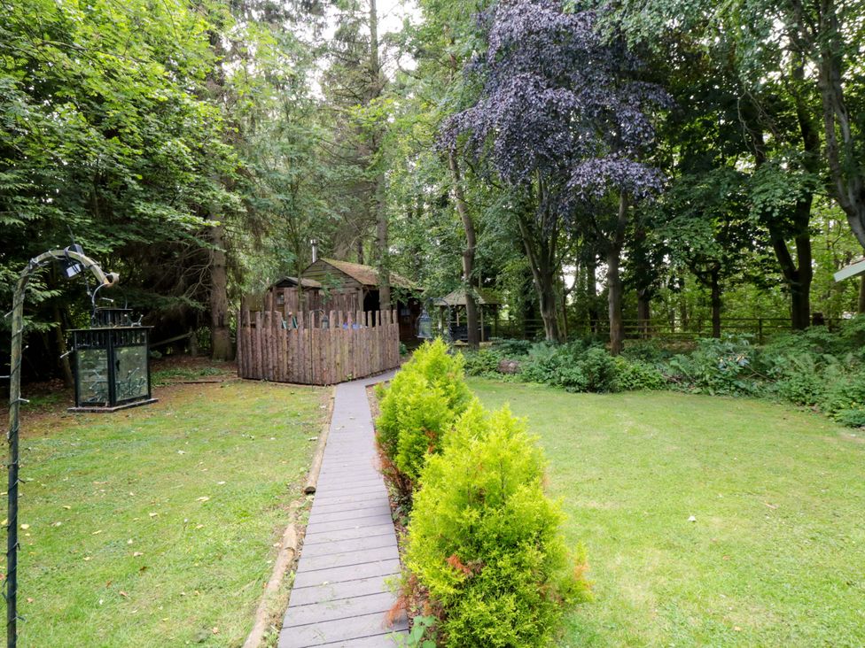 A garden with a pathway and shed at Lawnswood