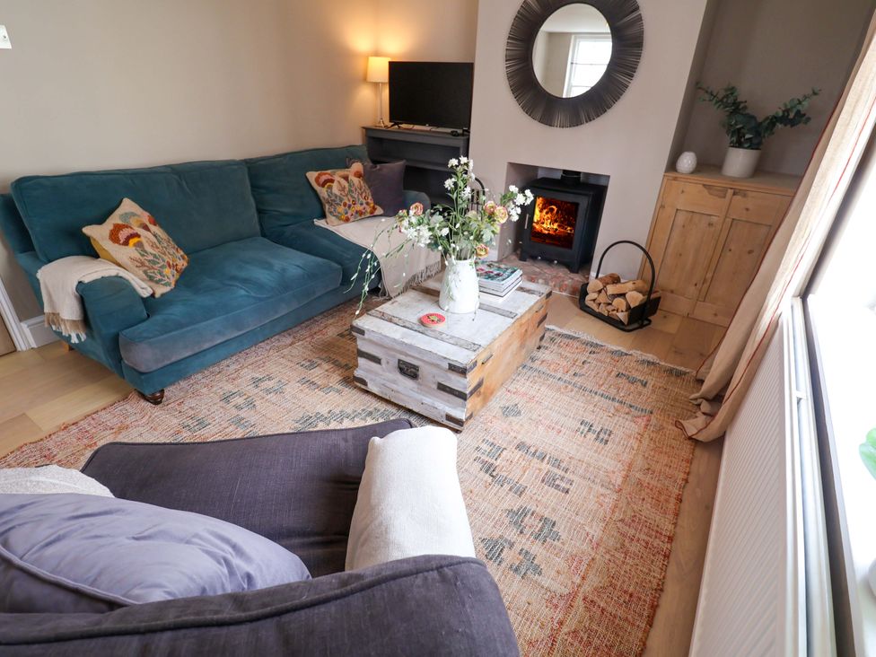 A living room with a blue sofa and coffee table at 11 Ballygate in Babbacombe