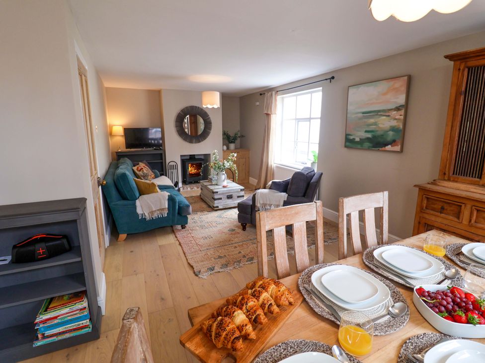 A dining room with a table set and a sofa at 11 Ballygate in Babbacombe