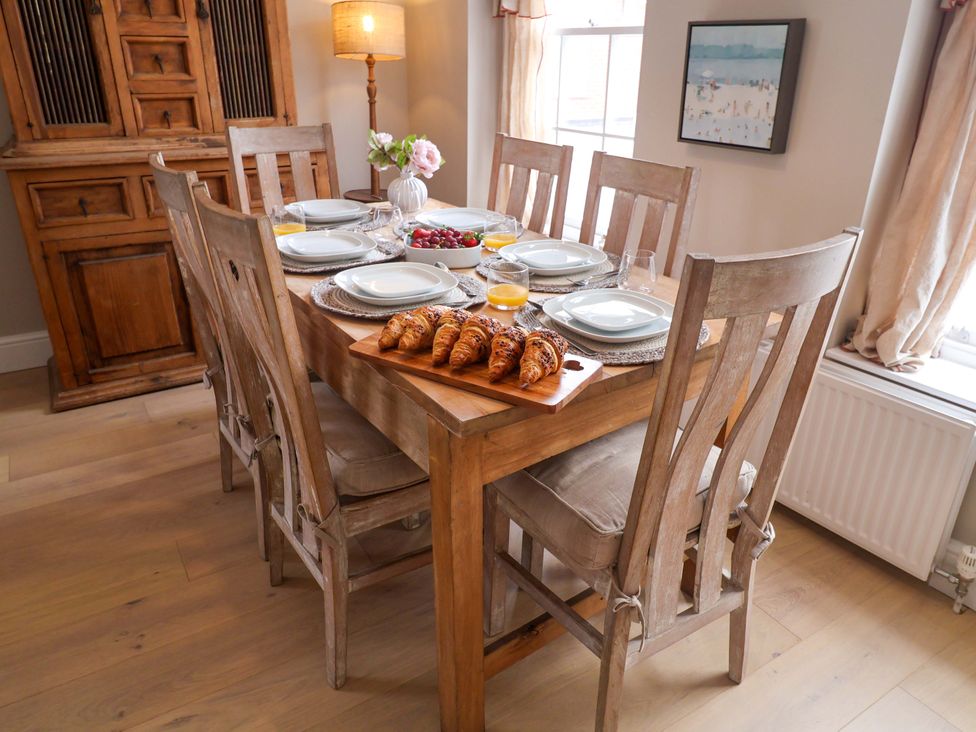 A dining room with a wooden table set with plates and croissants at 11 Ballygate Babbacombe