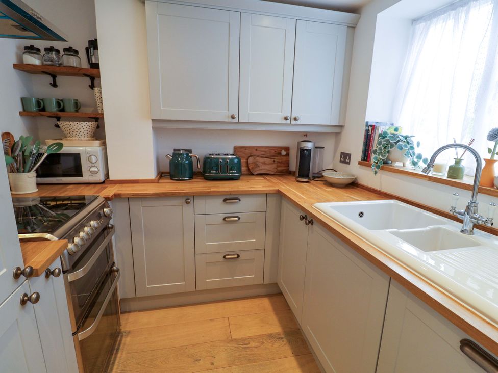 A kitchen with cabinets, stove, and sink at 11 Ballygate in Babbacombe