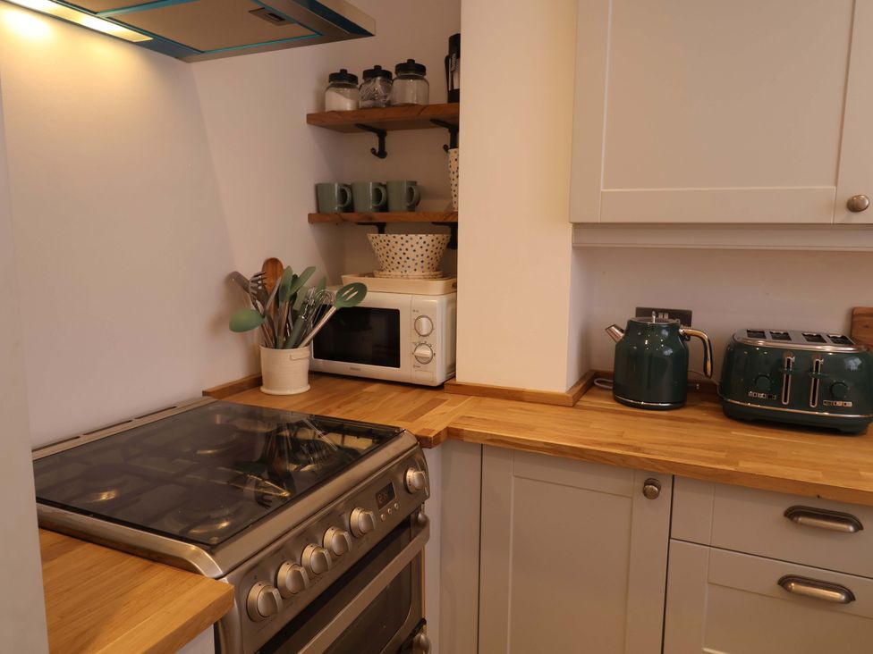 A kitchen with stove, microwave, kettle, and toaster at 11 Ballygate in Babbacombe