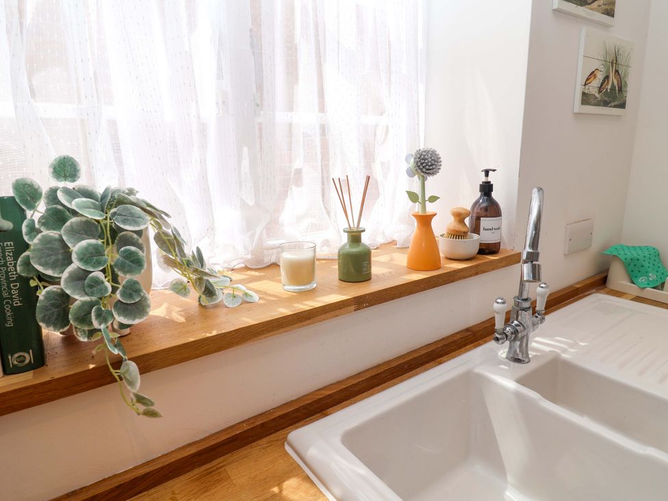 A kitchen sink with plants and decorative items at 11 Ballygate in Babbacombe