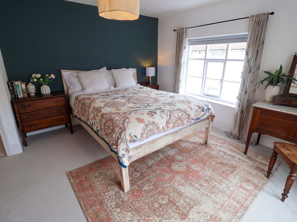 A bedroom with a bed, side tables, and a window at 11 Ballygate in Babbacombe