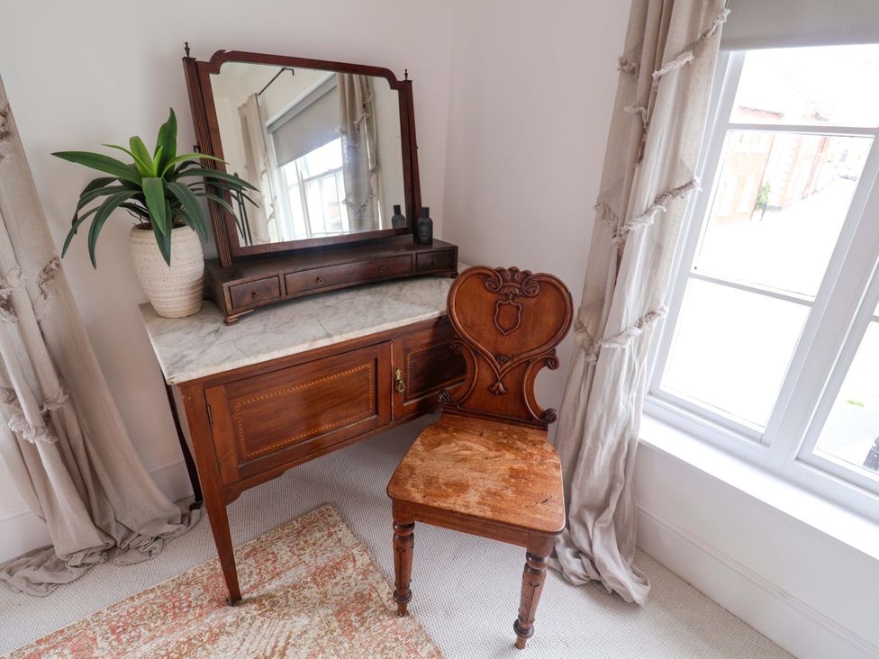 A bedroom with a dressing table and a chair at 11 Ballygate in Babbacombe