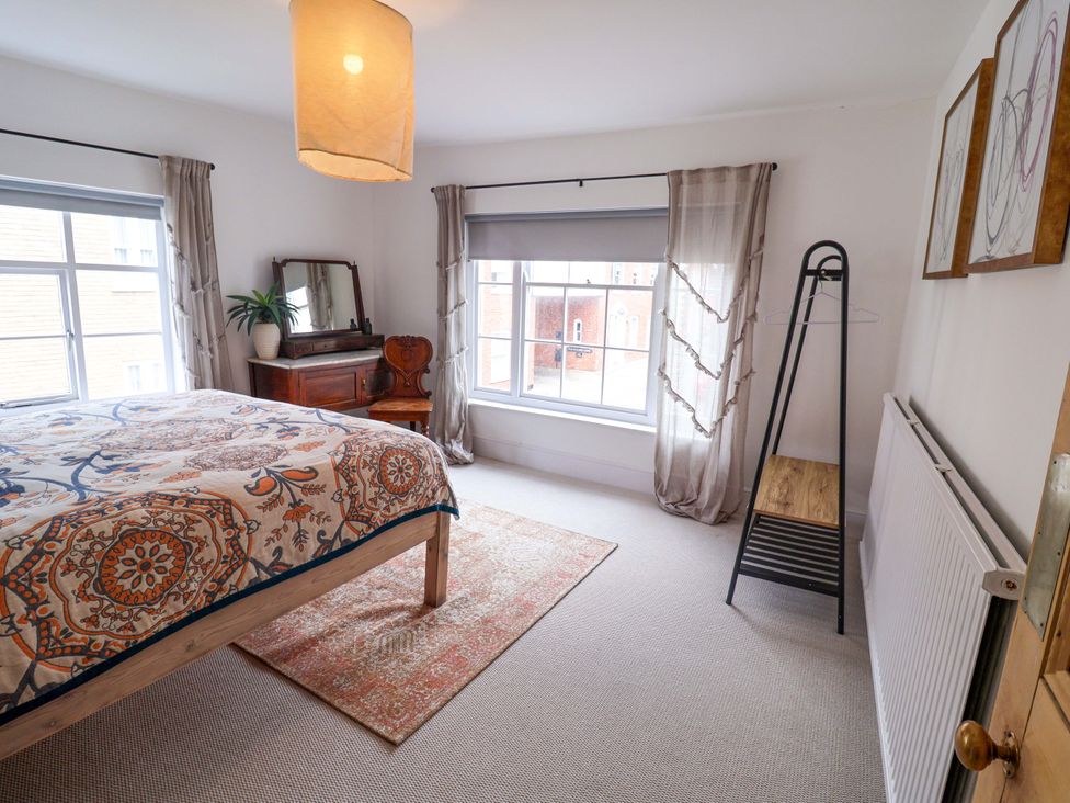 A bedroom with a bed and dresser at 11 Ballygate in Babbacombe