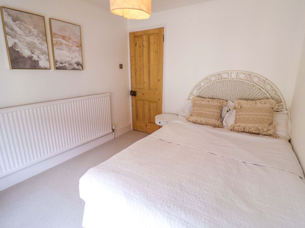 A bedroom with a bed and wall art at 11 Ballygate in Babbacombe