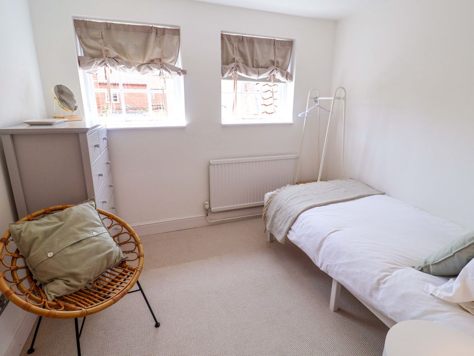 A bedroom with a bed and chair at 11 Ballygate in Babbacombe