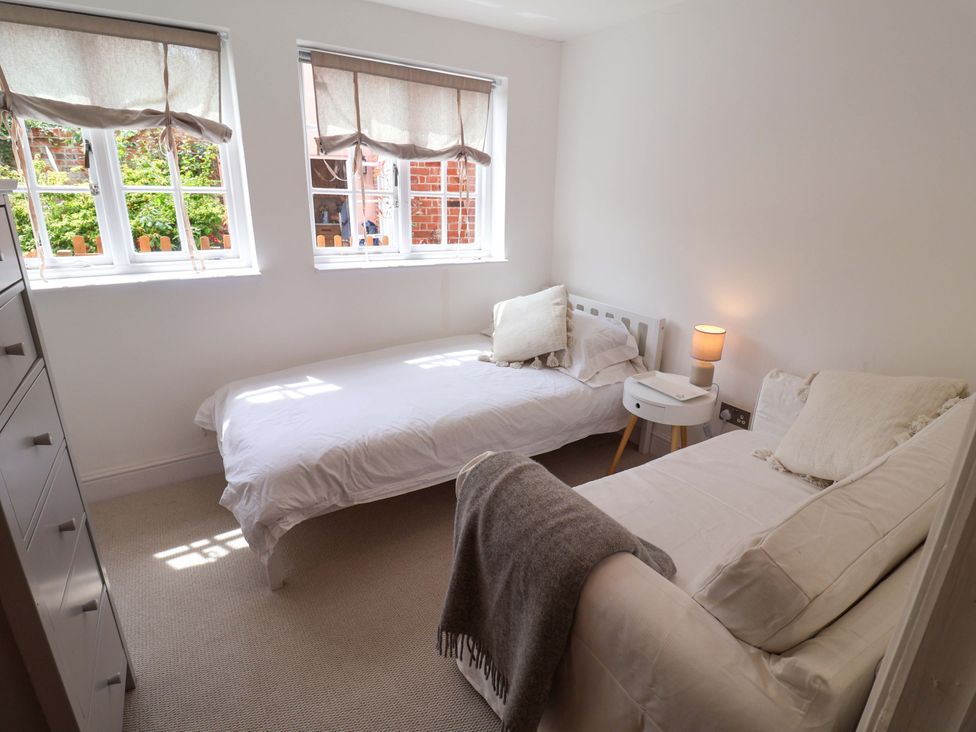 A bedroom with two beds and a nightstand at 11 Ballygate in Babbacombe