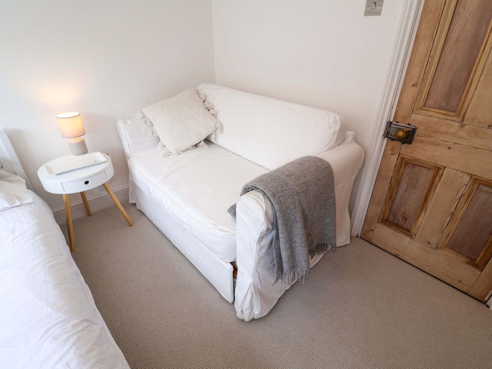 A bedroom with a sofa and bed at 11 Ballygate in Babbacombe