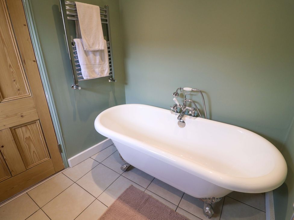A bathroom with a bathtub and towel rack at 11 Ballygate in Babbacombe