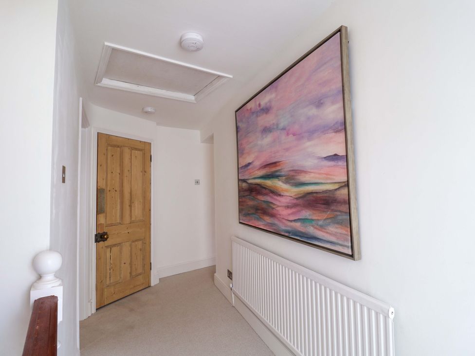 A hallway with a wooden door and large artwork at 11 Ballygate in Babbacombe