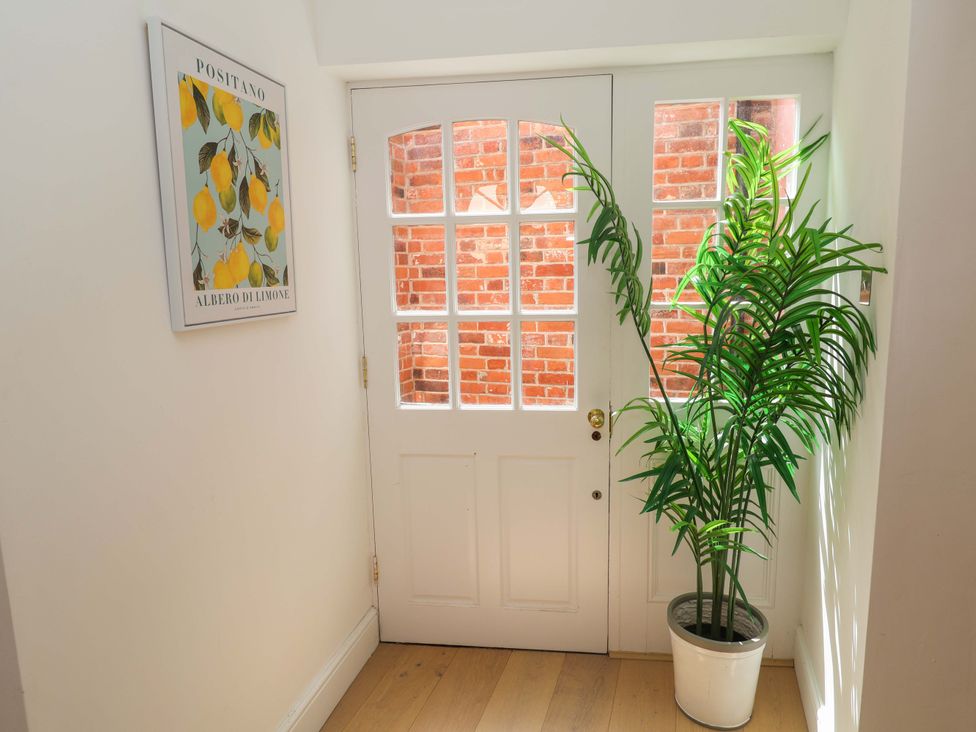 A hallway with a door and a potted plant at 11 Ballygate in Babbacombe
