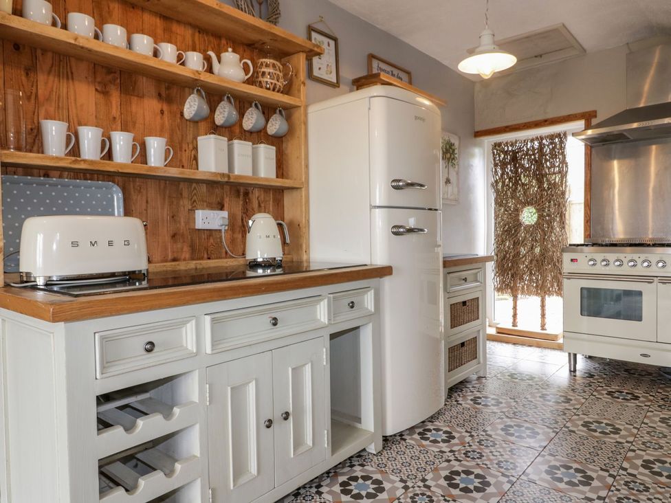 A kitchen with a refrigerator and oven at Sunset Cottage in Gorran Churchtown