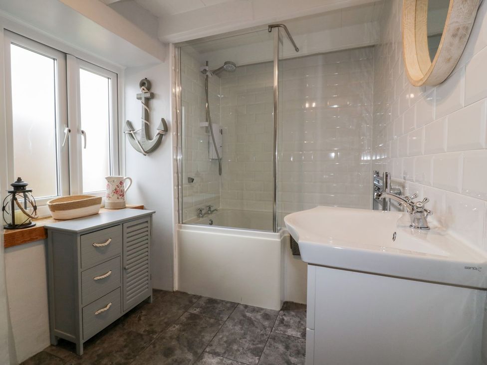 A bathroom with bathtub and sink at Sunset Cottage in Gorran Churchtown