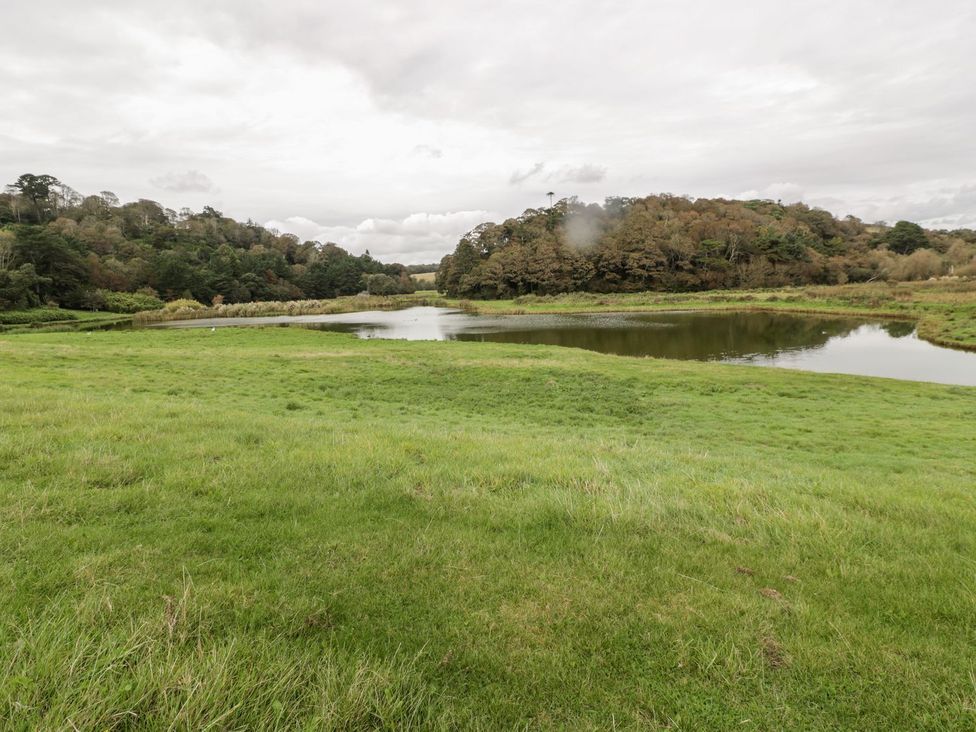 A landscape with a pond and grassland at Sunset Cottage in Gorran Churchtown
