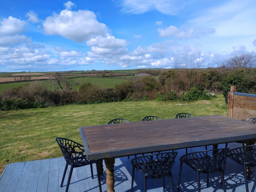 An outdoor seating area with table and chairs at Sunset Cottage Gorran Churchtown
