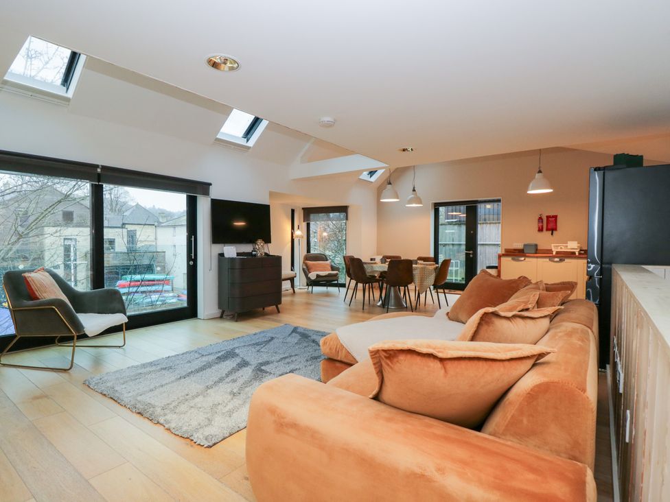 A living room with a sofa and dining area at 3 The Stoneyard in Bath