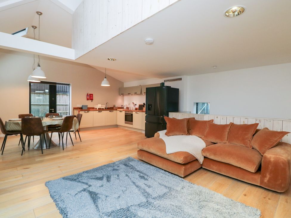 A living room with a sofa and dining area at 3 The Stoneyard in Bath