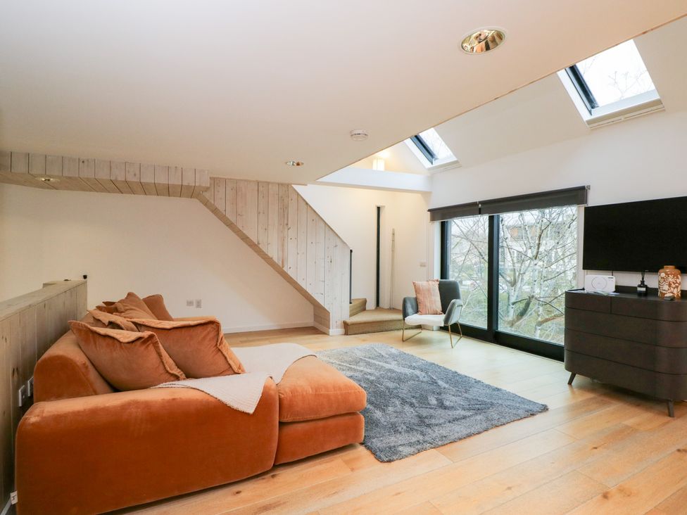 A living room with a sofa and a television at 3 The Stoneyard Bath