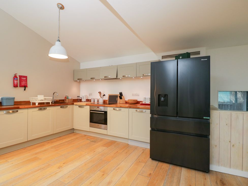 A kitchen equipped with a refrigerator, oven, and cabinets at 3 The Stoneyard Bath