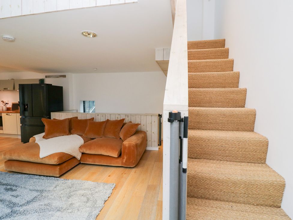 A living room with a sofa and staircase at 3 The Stoneyard in Bath