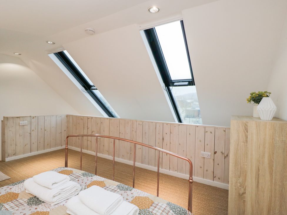 A bedroom with a bed and windows at 3 The Stoneyard in Bath