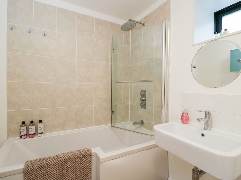 A bathroom with a bathtub and sink at 3 The Stoneyard in Bath