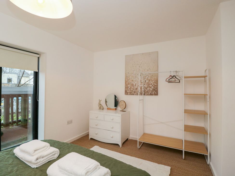 A bedroom with a bed and a wardrobe at 3 The Stoneyard Bath