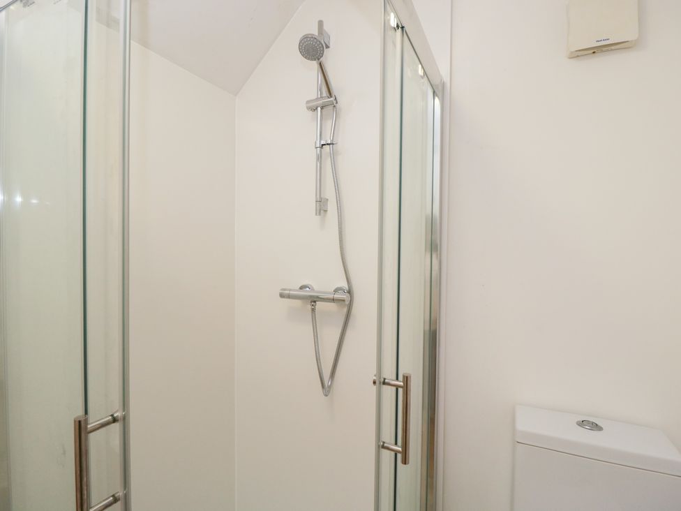 A shower with glass door and toilet at 3 The Stoneyard Bath