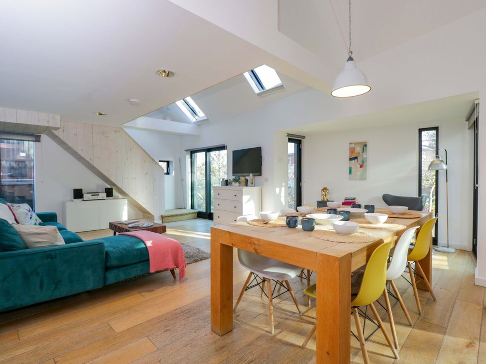 A living room with a sofa and dining table at 4 The Stoneyard in Bath