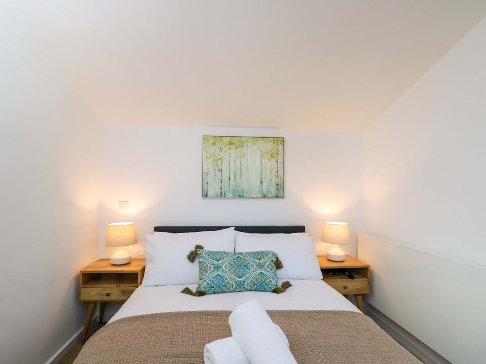 A bedroom with a bed and nightstands at 4 The Stoneyard Bath