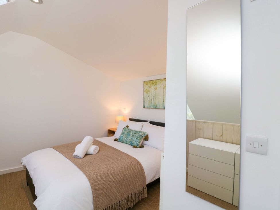 A bedroom with a bed and a mirror at 4 The Stoneyard Bath