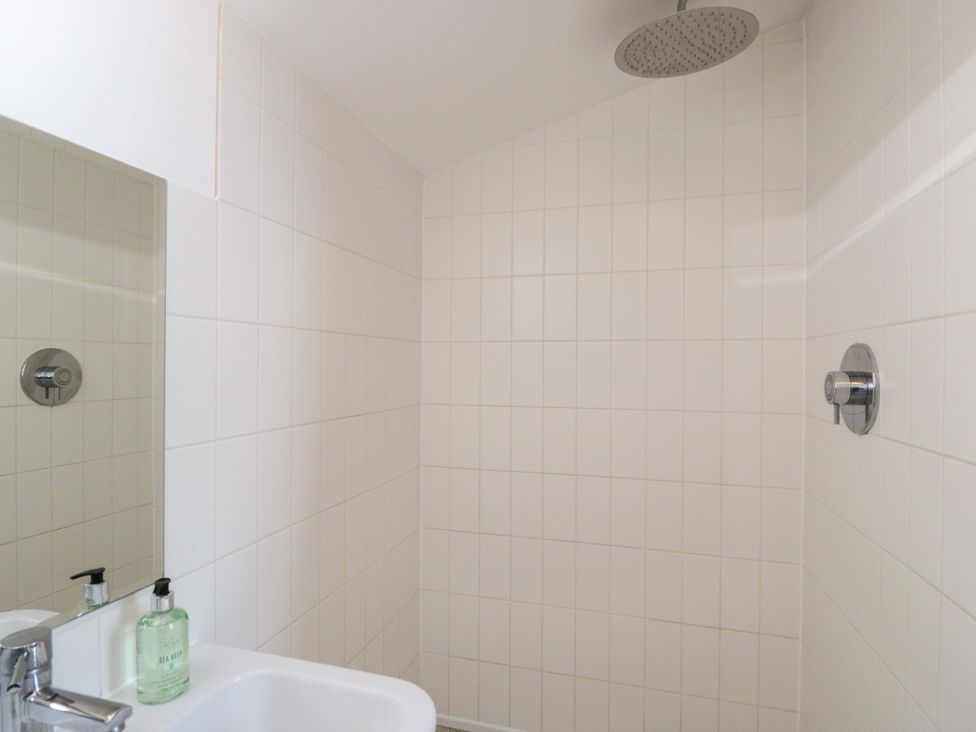 A bathroom with a shower and sink at 4 The Stoneyard Bath