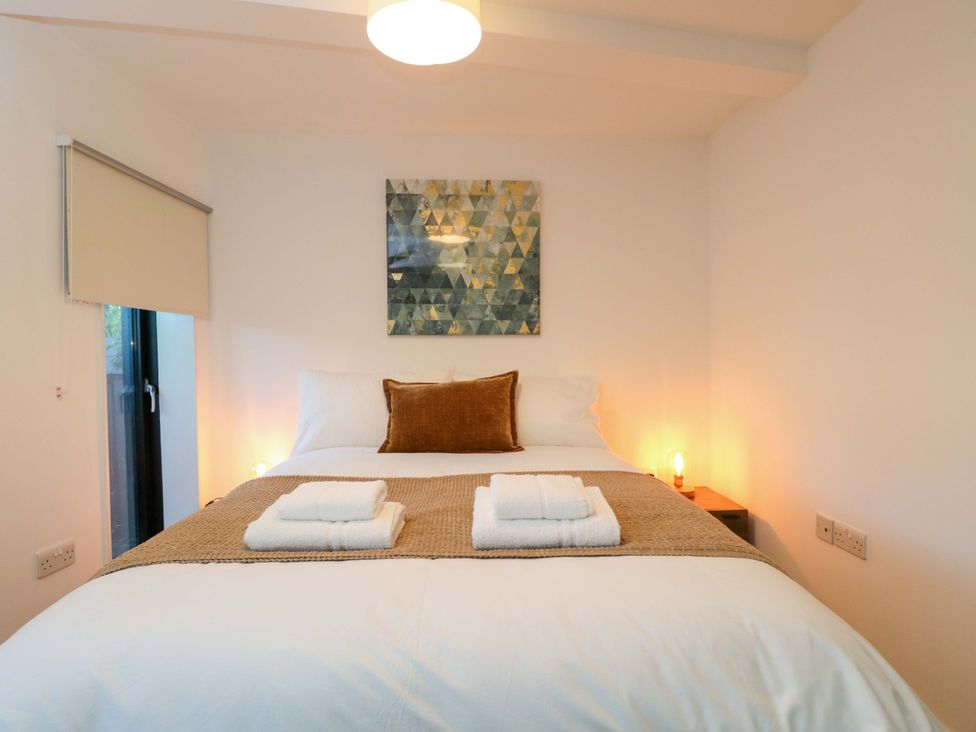 A bedroom with a bed and artwork on the wall at 4 The Stoneyard in Bath