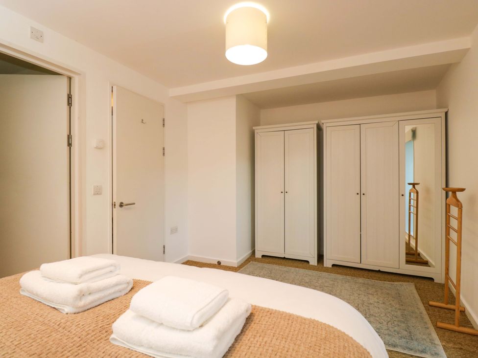 A bedroom featuring a bed with towels and wardrobes at 4 The Stoneyard in Bath