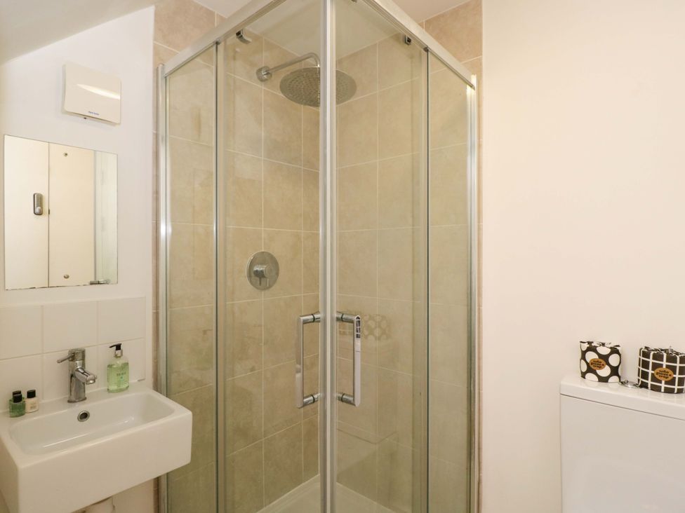 A bathroom with a shower and sink at 4 The Stoneyard Bath