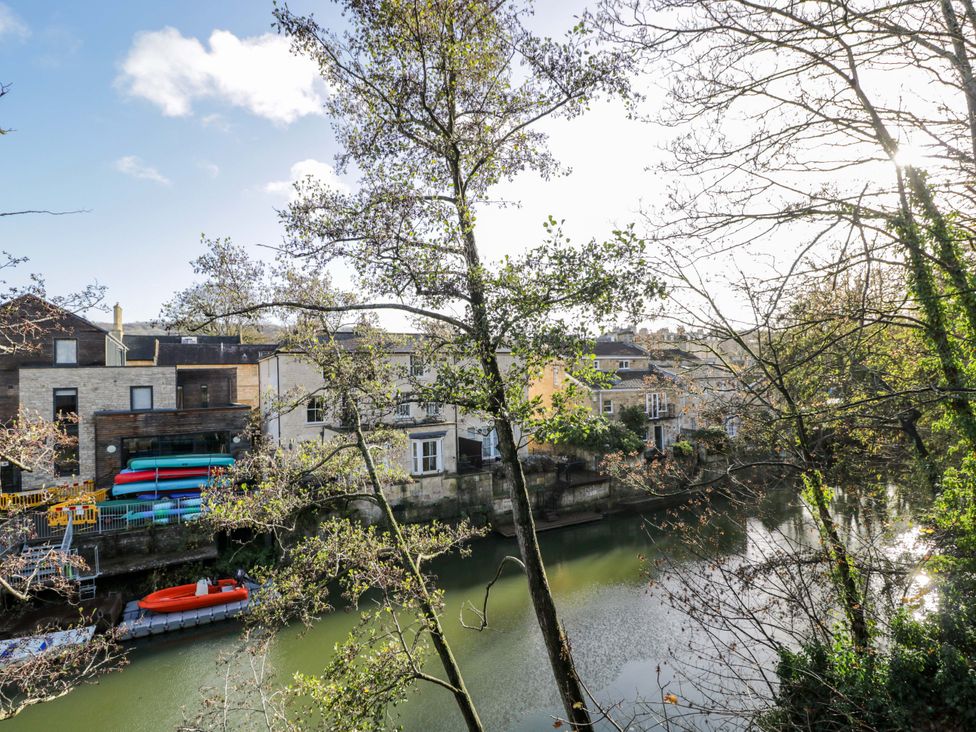 View of buildings and boats by a river with trees at 4 The Stoneyard Bath