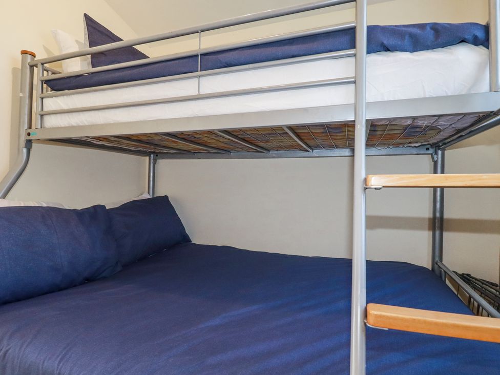 A bunk bed with metal frame and blue bedding in a bedroom at 101 Atlantic Bays Holiday Park Padstow