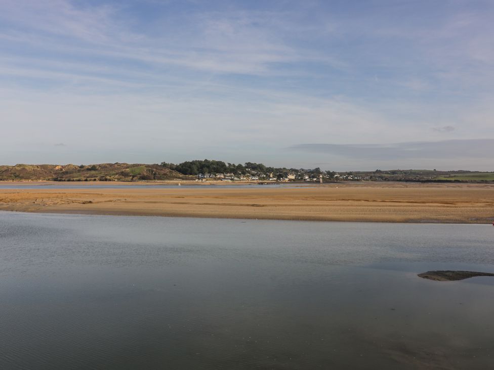 A coastal landscape with water and sandbanks and houses in the distance at 101 Atlantic Bays Holiday Park in Padstow