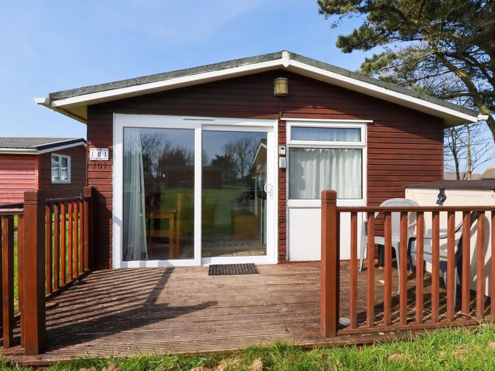 A cabin with a deck and sliding door at 101 Atlantic Bays Holiday Park in Padstow