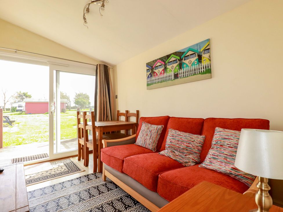A living room with a sofa and dining table at 101 Atlantic Bays Holiday Park in Padstow