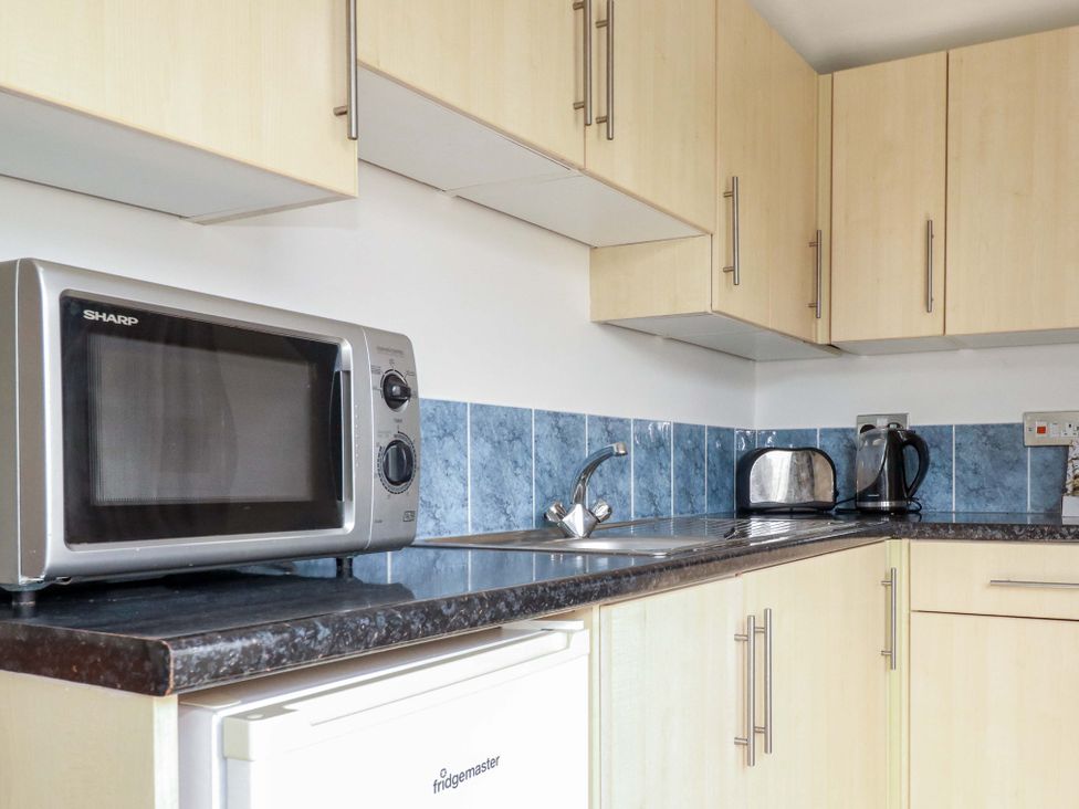 A kitchen with a microwave, sink, kettle, and toaster at 101 Atlantic Bays Holiday Park in Padstow