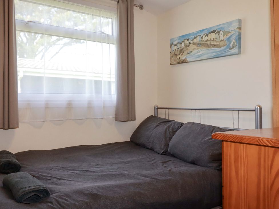 A bedroom with a bed and window at 101 Atlantic Bays Holiday Park in Padstow