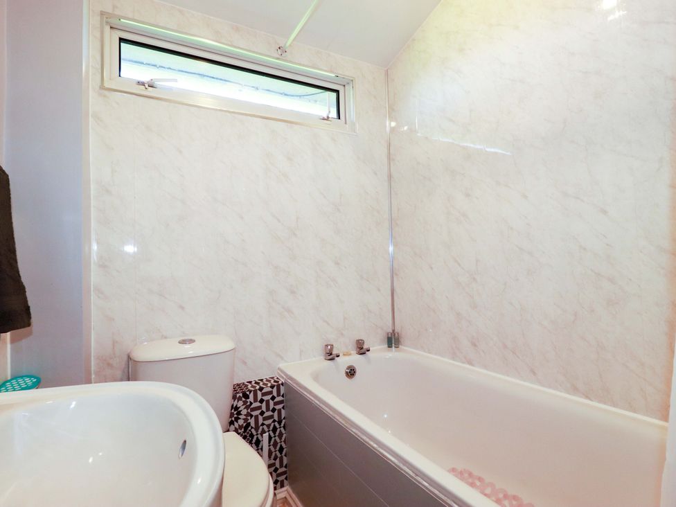 A bathroom with a bath tub, toilet, and sink at 101 Atlantic Bays Holiday Park, Padstow