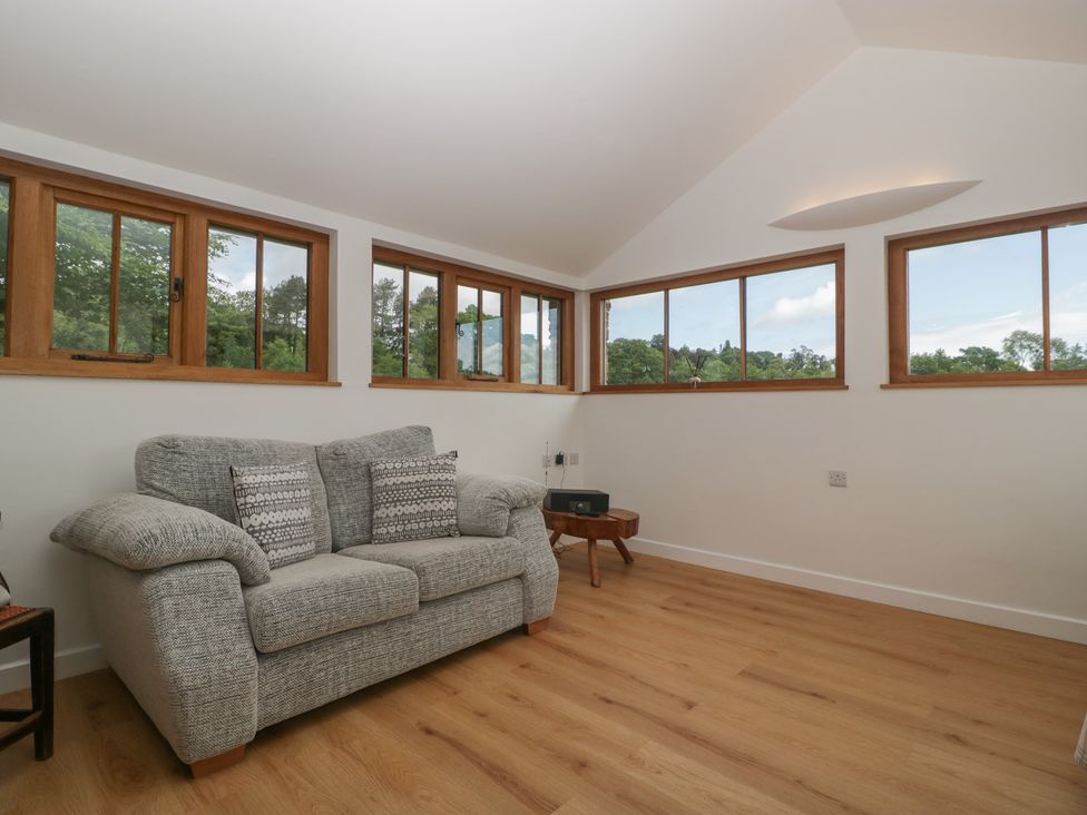 A living room with a sofa and windows at Ynys Pandy near Ewyas Harold