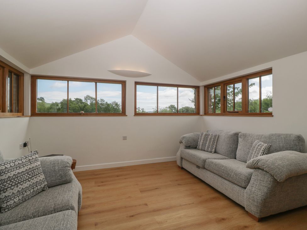 A living room with two sofas and large windows at Ynys in Pandy near Ewyas Harold