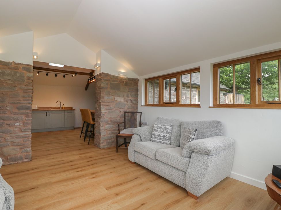 A living room with a sofa and kitchen island at Ynys Pandy near Ewyas Harold